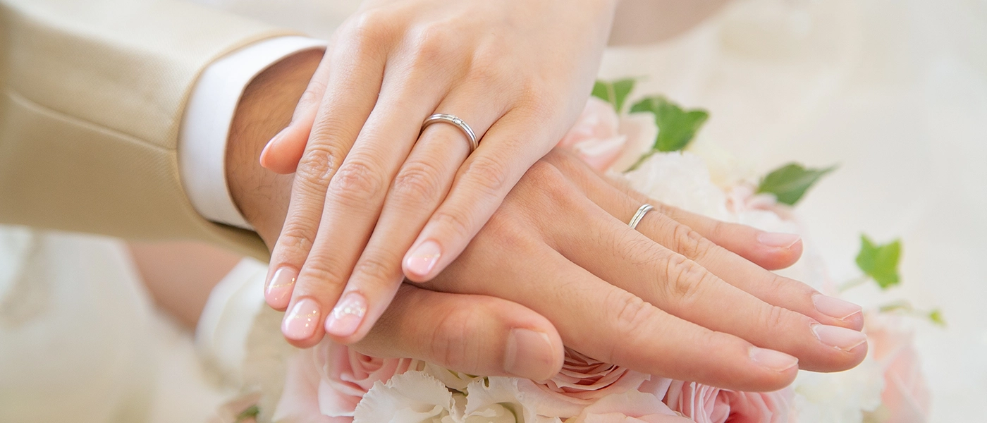 重ねた手元に輝く結婚指輪