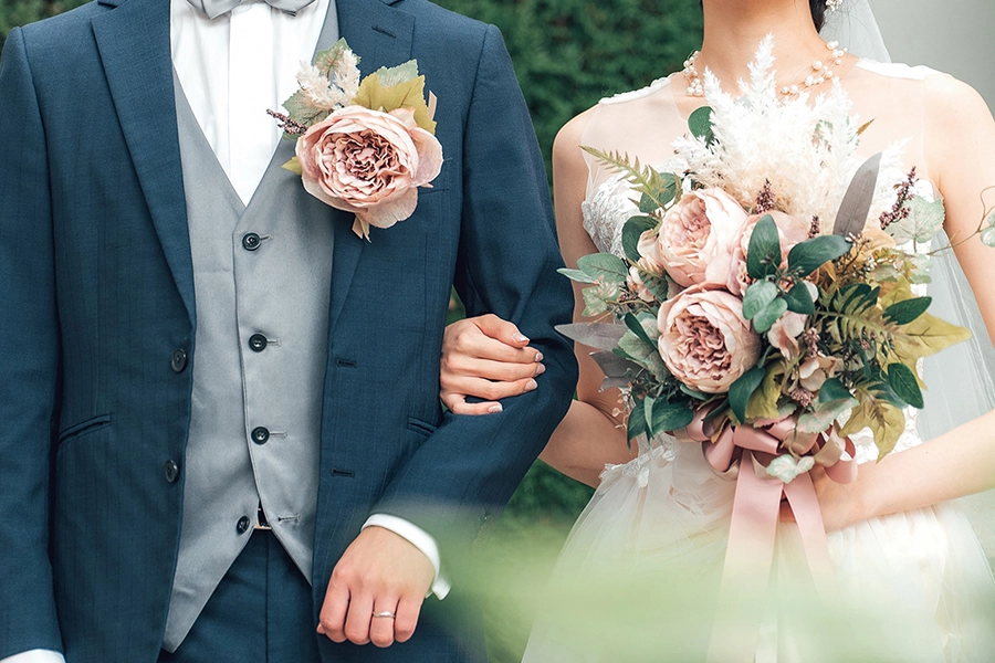 ブーケを手に腕を組む新郎新婦