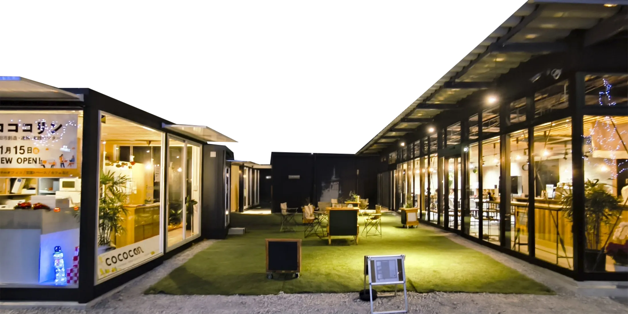 夜のコココリン。ガラス張りの建物に囲まれた芝生の中庭